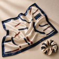 Woman wearing a navy and burgundy silk scarf with a matching scrunchie